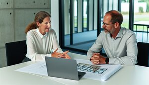 Europäische Fachleute in einem deutschen Büro besprechen Baupläne für modulare Gebäude
