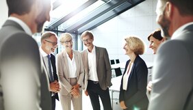 Europäische Fachleute im angeregten Gespräch bei einem Netzwerktreffen in einem modernen deutschen Büro