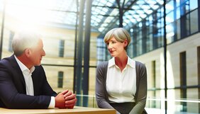Europäische Fachleute in einem deutschen Büro bei einem vertrauensvollen Arbeitsgespräch an einem Konferenztisch