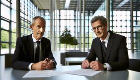 Zwei europäische Geschäftsleute in einem deutschen Büro bei einem vertrauensvollen Gespräch über langfristige Zusammenarbeit