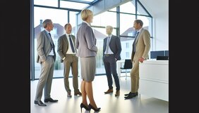 Europäische Fachleute im vertrauensvollen Beratungsgespräch an einem Besprechungstisch in einem deutschen Büro