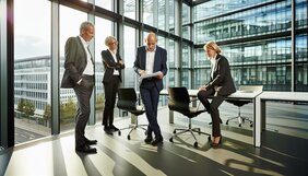 Europäisches Expertenteam bespricht Immobilienprojekt an einem modernen Konferenztisch mit Unterlagen und Stadtplan