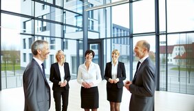 Gruppe europäischer Fachleute im Gespräch bei einem informellen Netzwerktreffen in einem modernen Büro